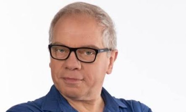 Marco Marzocca, ritratto con occhiali e camicia blu