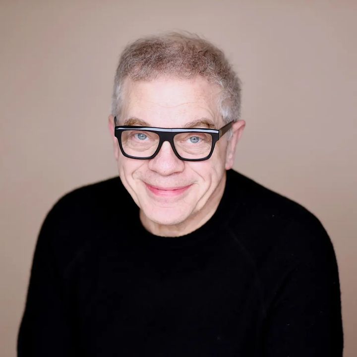 Ritratto di Marco Marzocca con occhiali neri e maglione scuro